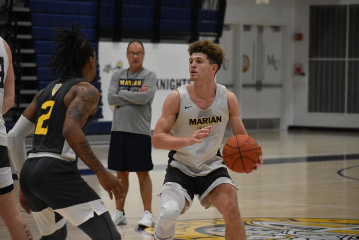 Marian coach Scott Heady watches Christian Harvey (2) defend Rowen Farrell during practice.